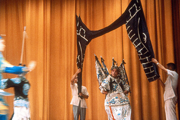 Помощники изображают с помощью ткани городские ворота на сцене